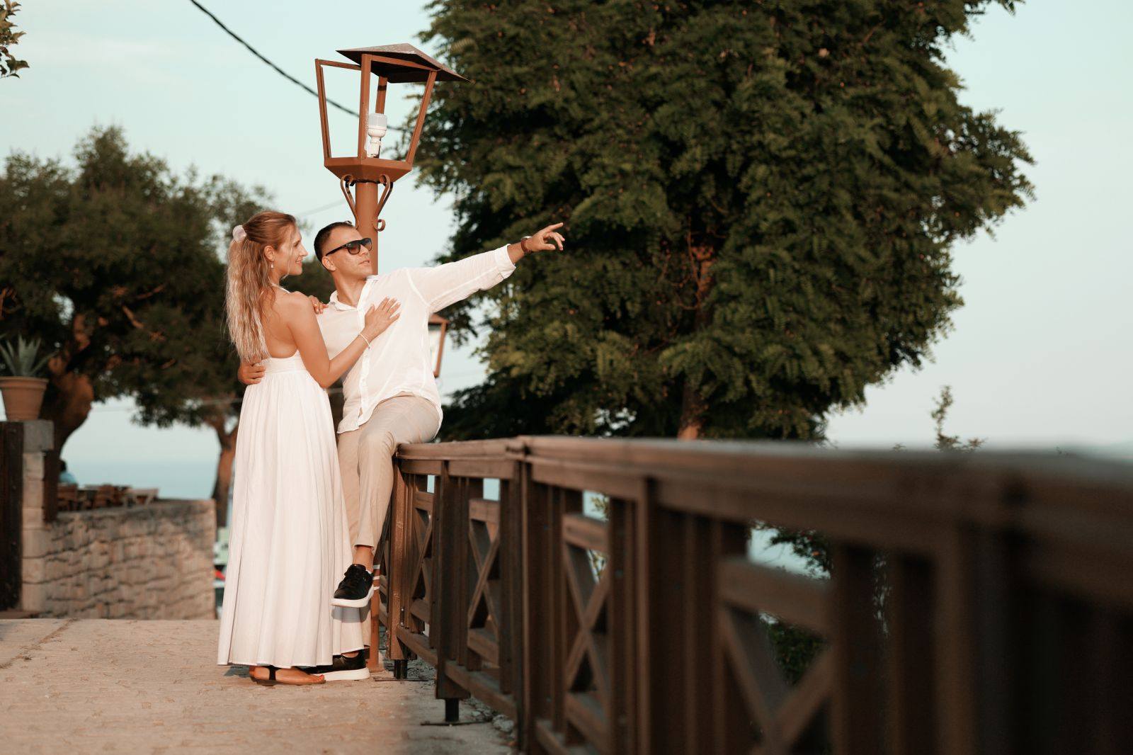 Пар на тераса при залез, гледаат кон морето