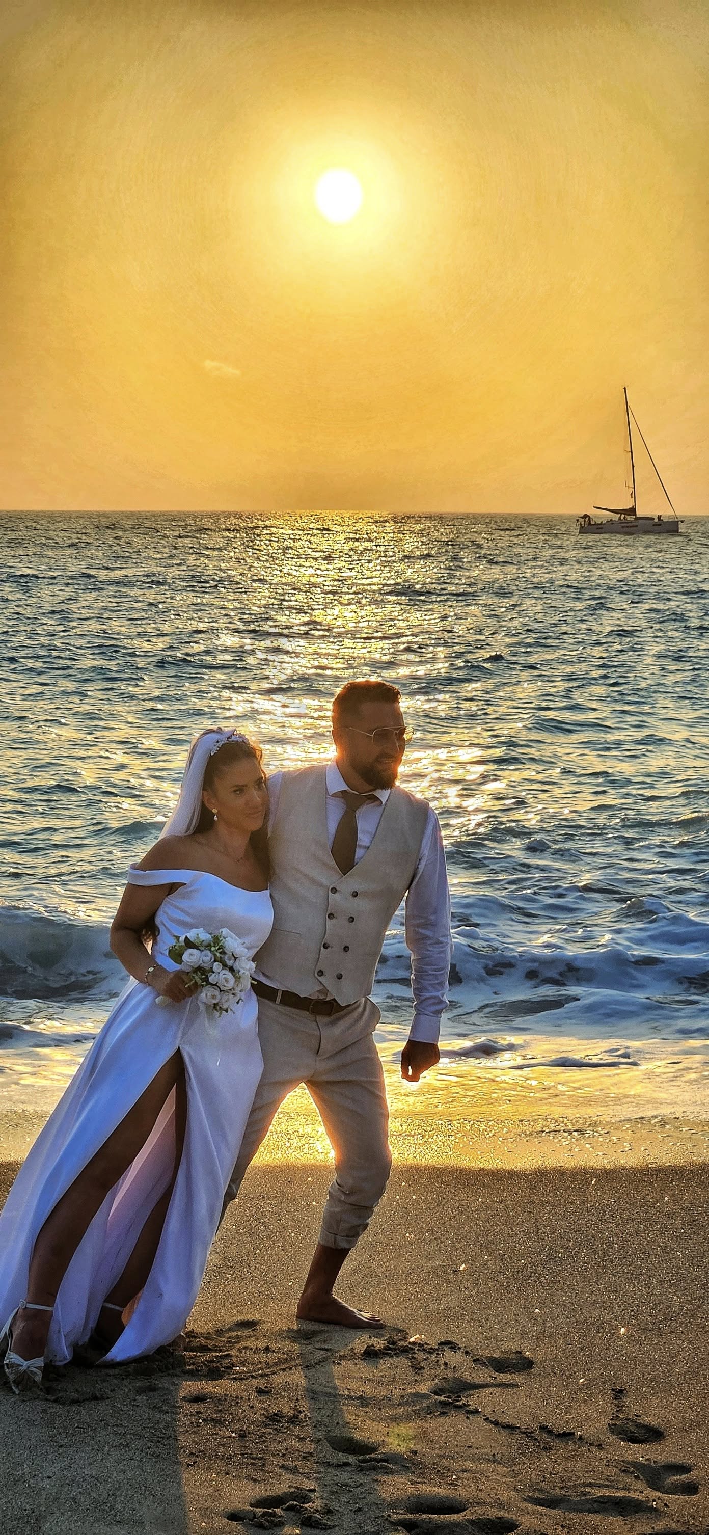 Пар на плажа при залез со едрилица