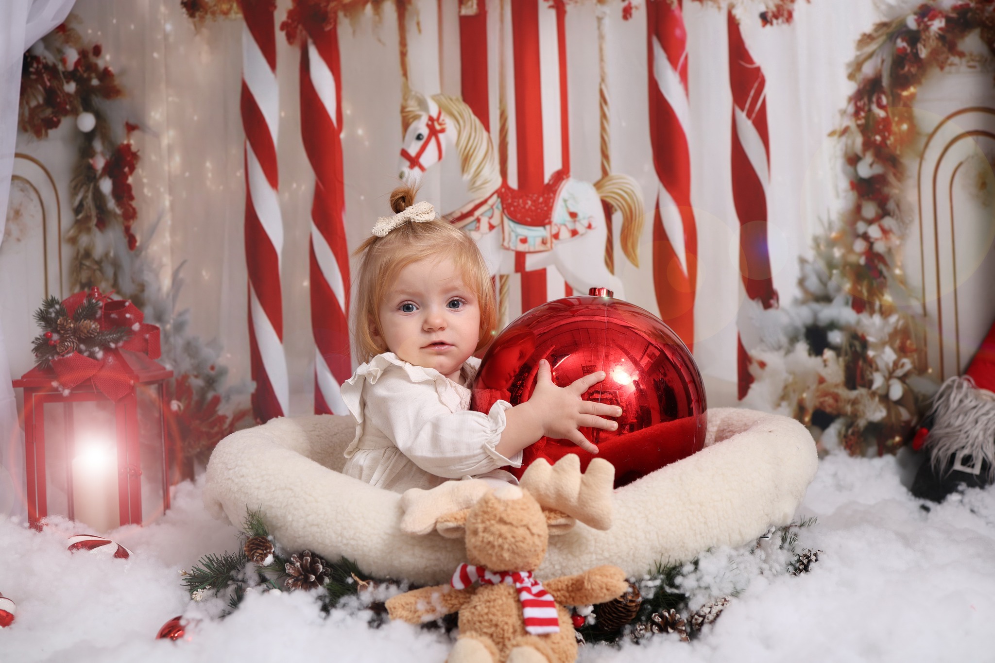 Мало девојче грли огромна црвена Божиќна топка